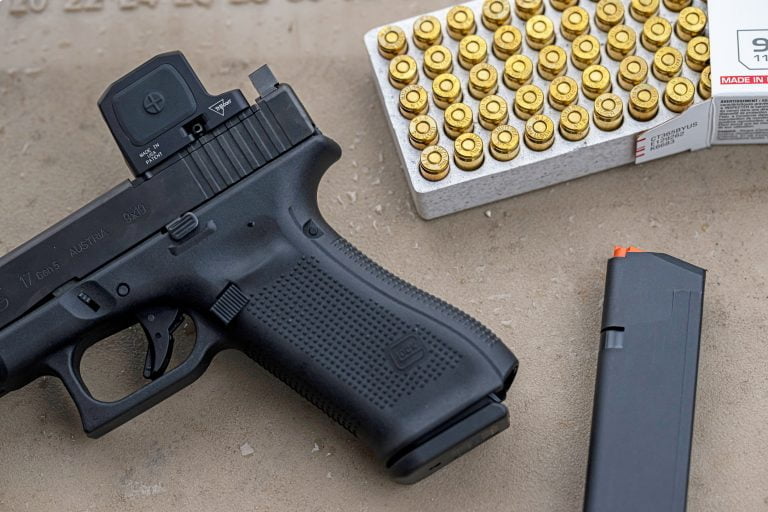 Trijicon RCR on Glock handgun on bench with 9mm rounds in a box